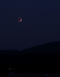 During a total lunar eclipse, the moon doesn't completely disappear because some sunlight passes through Earth’s atmosphere and is refracted and refocused on the moon.