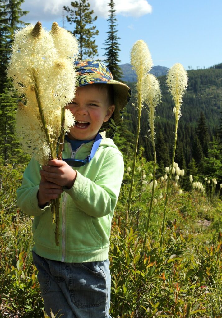 Young boy with a handful of beargrass blossoms.