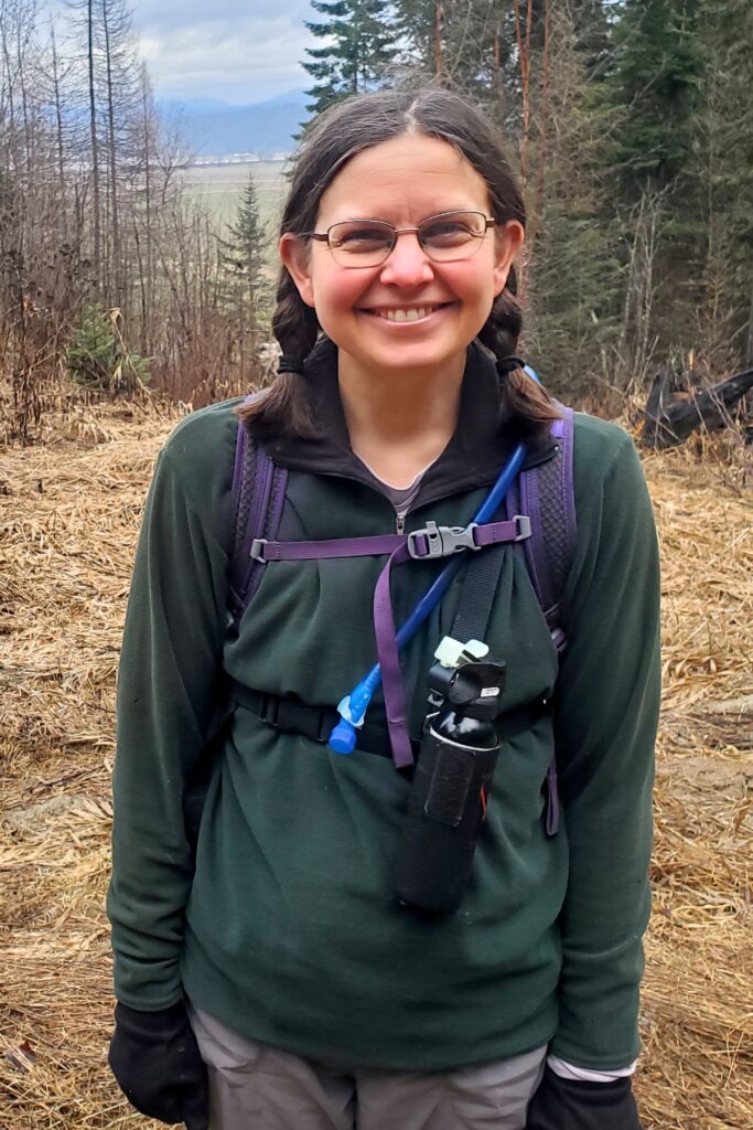 A lady carrying bear spray in a chest harness.
